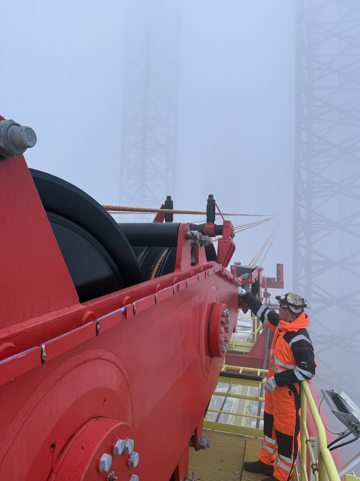 Industrimedarbejder i orange overalls på offshore-udstyr